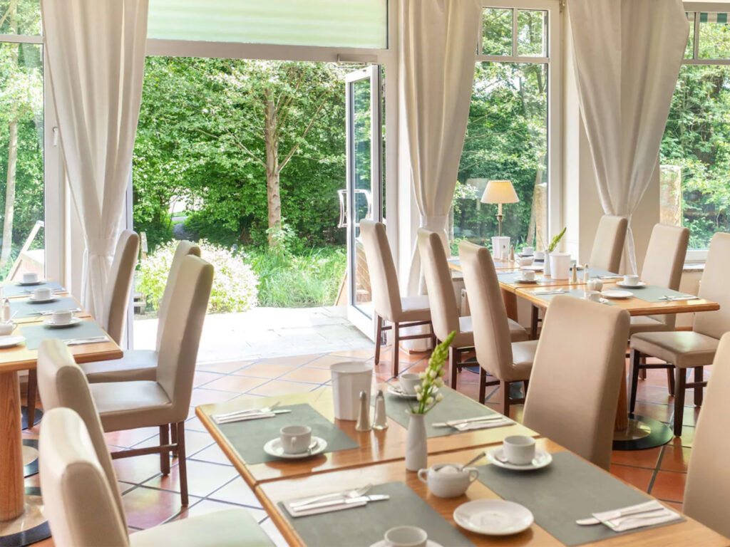 Einblick in den Frühstücksraum im Hotel Lübecker Hof in Stockelsdorf mit gedeckten Tischen