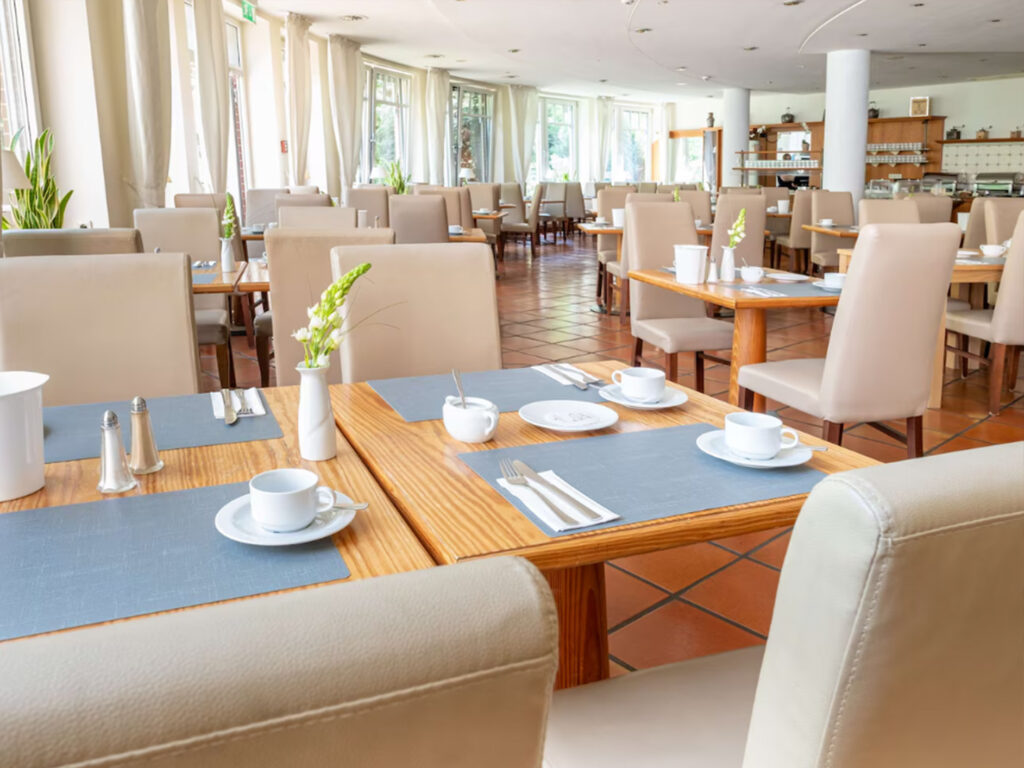 Einblick in den Frühstücksraum im Hotel Lübecker Hof in Stockelsdorf mit gedeckten Tischen